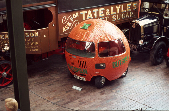 A spherical car moulded to look like an orange including dimpling and a stork at the top; with 'outspan' written on it.
It's in a museum, at the back of it is a Tate & Lyle's sugar truck, and other vehicles.