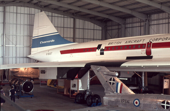 The outside of the Concorde, showing the tail fin marked 'Concorde', the G-BSST serial number, and most of the 'British Aircraft Corpora..tion' 