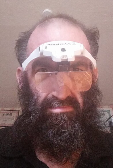 Myself (beardy and balding) wearing a magnifying head visor with the lenses on my nose.