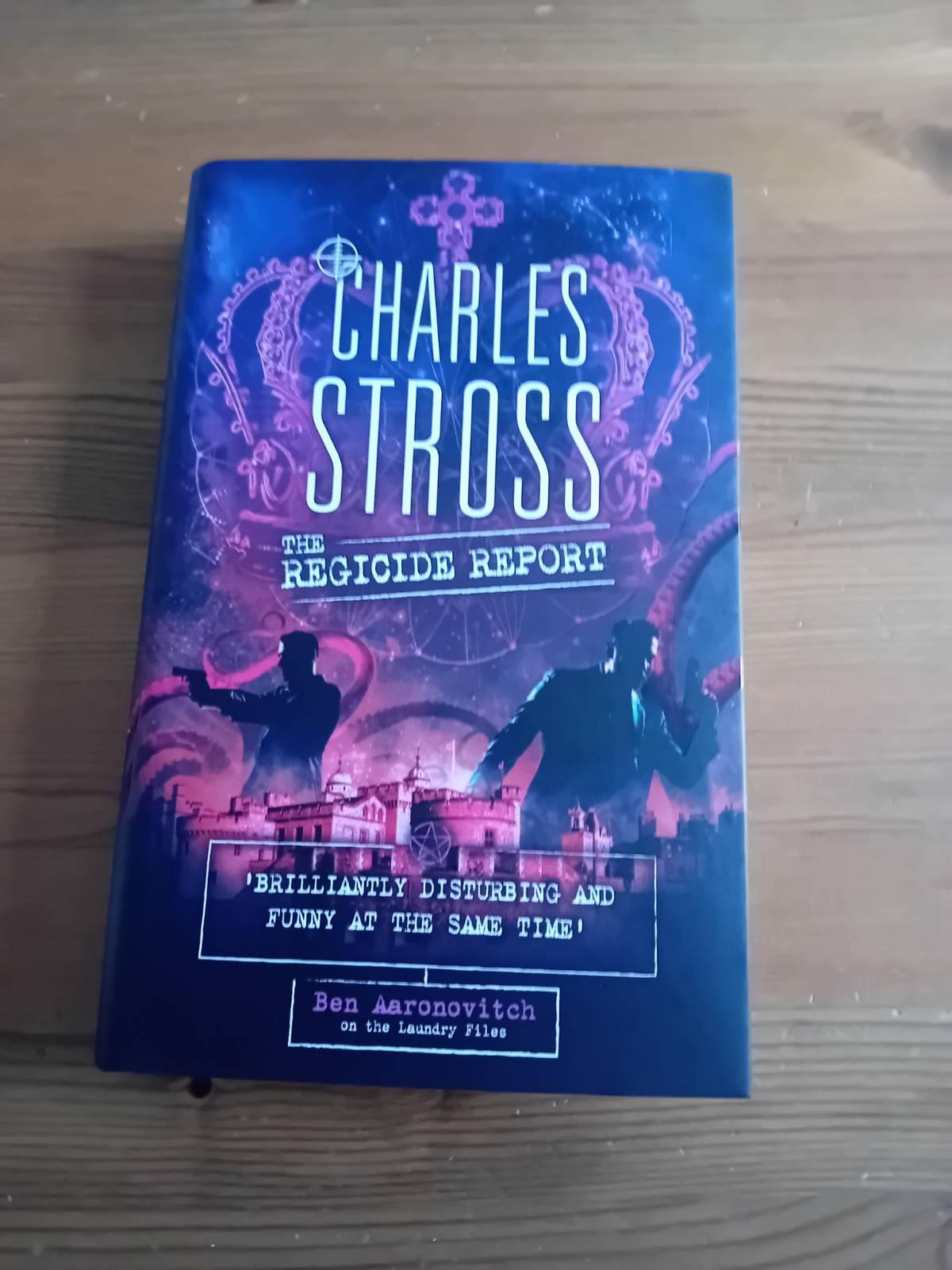 A picture of Charles Stross's _The Regicide Report_, in hardback on a wooden surface.