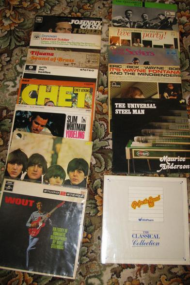 A selection of vinyl records on a flowery carpet.  Some are well known (e.g. Johnny Cash I walk the line, 'With the beatles etc); then there's ones I'd not heard of like Wout Steenhuis.  Then there's a classic record that's a promotional one from a pharamacy wholesaler.