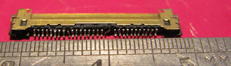 A 30 pin EDP connector along side a 0.5mm steel rule; the connector has lost a few pins and isn't that happy - it's about 15mm wide.