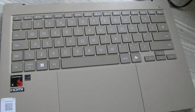 An Asus laptop base; with no top cover.  It has a 'Snapdragon X' sticker and an auction sticker.  