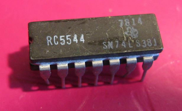 An old ceramic packaged 74LS38;  It's 14 (slightly wonky) pins, and it's a classic twiple layer black on top and bottom with white middle layer.  Labelled 'RC5544,  7814, SN74LS38J' with a TI logo