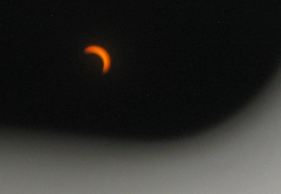 A curved edge of sun as seen through some glasses