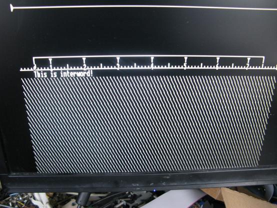 A screenshot showing the working screen of 'Interword' - it's a black and white screen with a line at the top, then a ruler marking out text columns, then text ''This is Interword!' which I typed and then a fill at the bottom.